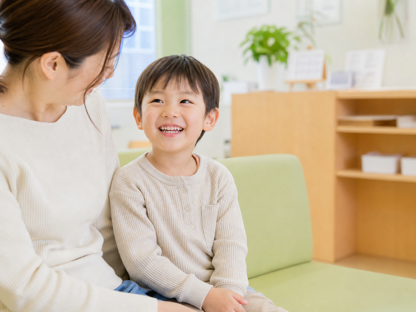 待合室で笑顔を見せるお子さんと保護者